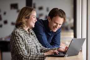 To forretningsrådgivere i en samtale foran en laptop. Foto.