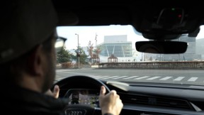 Mann som kjører bil foran Operaen. Foto.