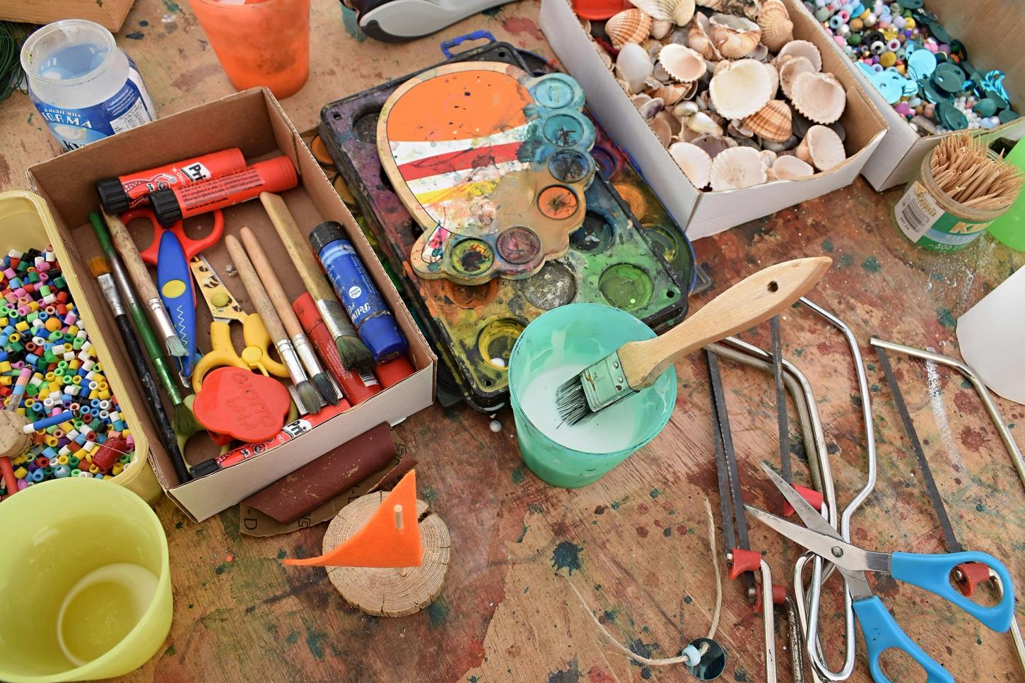 Beholdere med perler, pensler, fargeblyanter, skjell. Utstyr til forskjellige verkstedsaktiviteter.