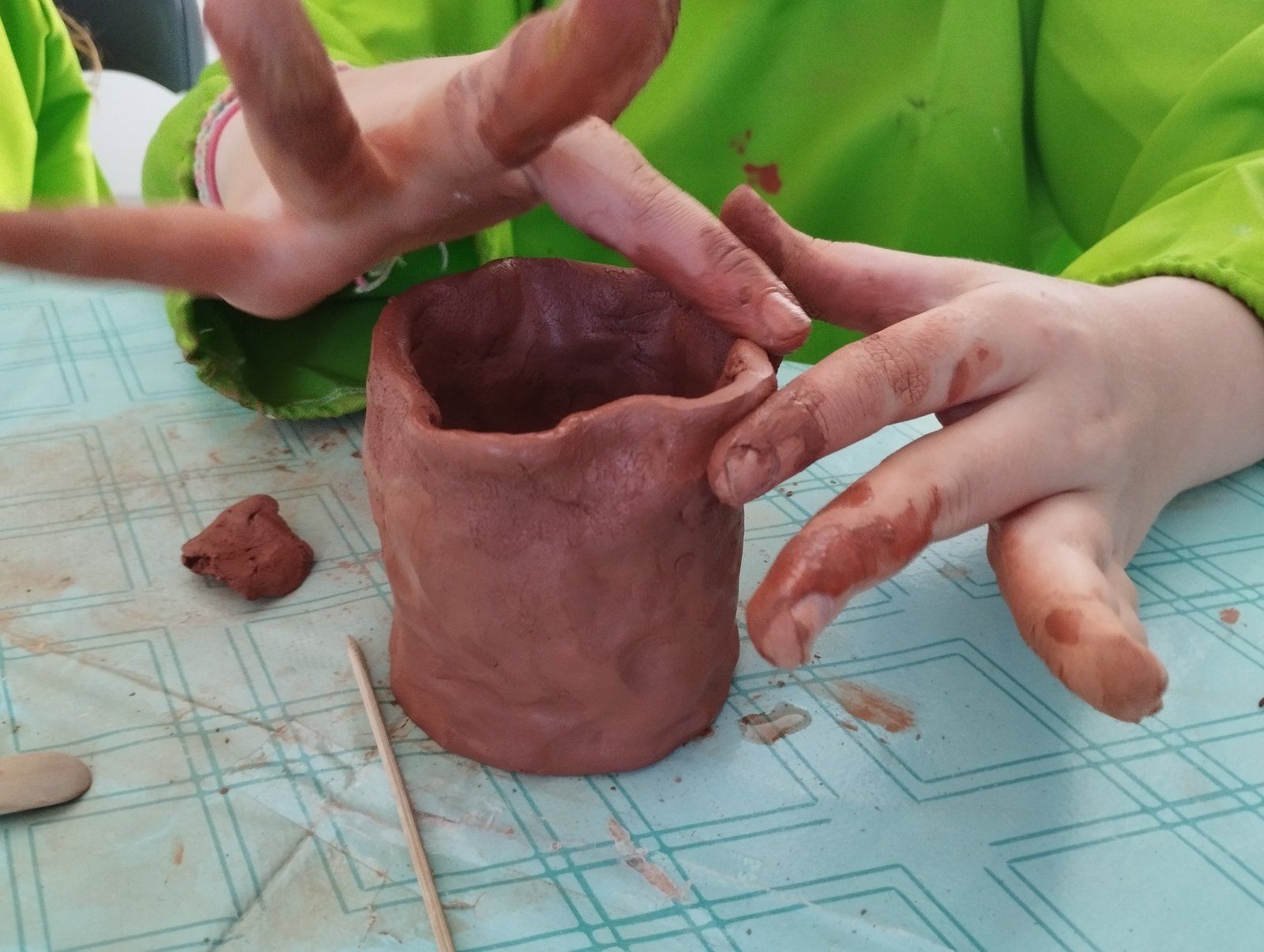 Des mains façonnent un pot en argile