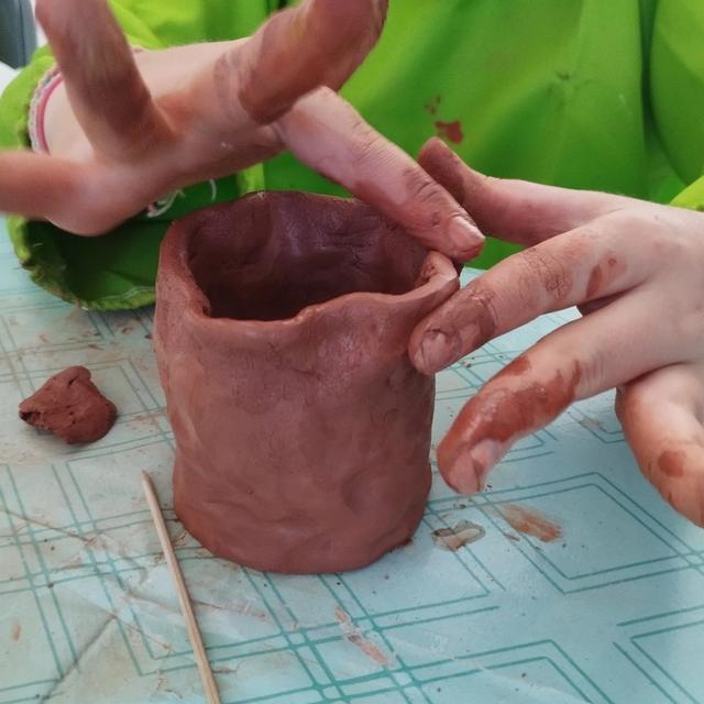 Des mains façonnent un pot en argile
