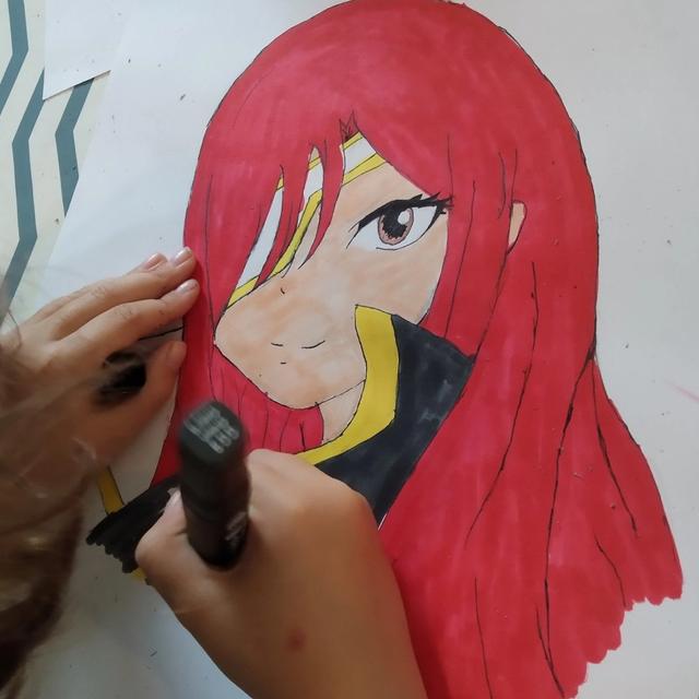Un personnage de manga aux cheveux rouges, mis en couleur au feutre
