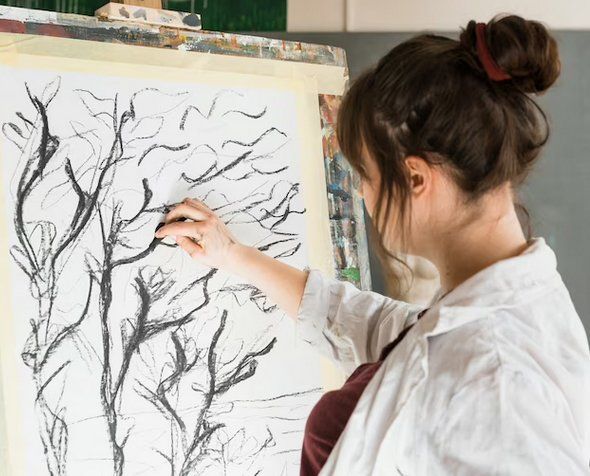 Une ado peint des arbres à l'encre noire