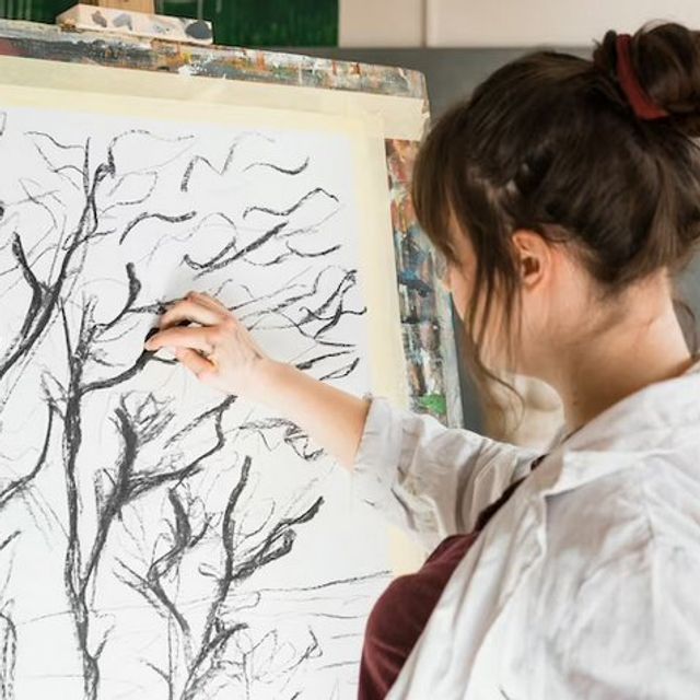 Une ado peint des arbres à l'encre noire