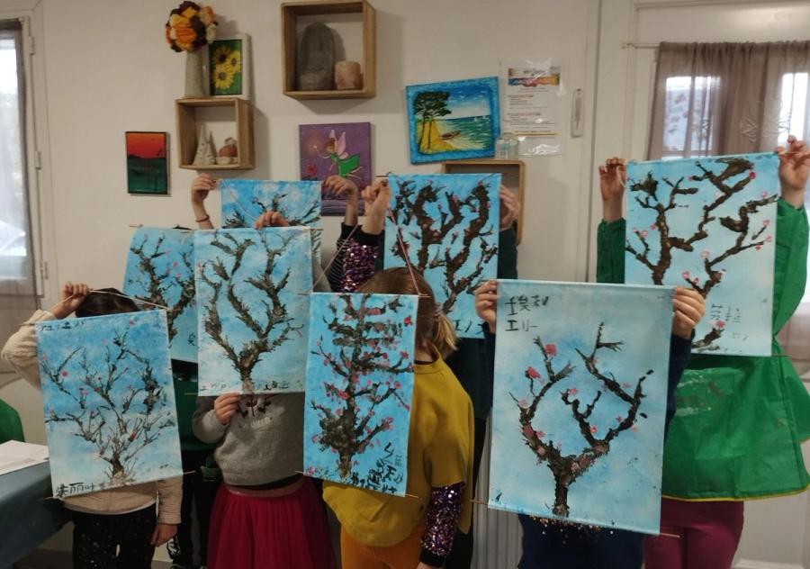 Des enfants montrent leurs peintures d'arbres