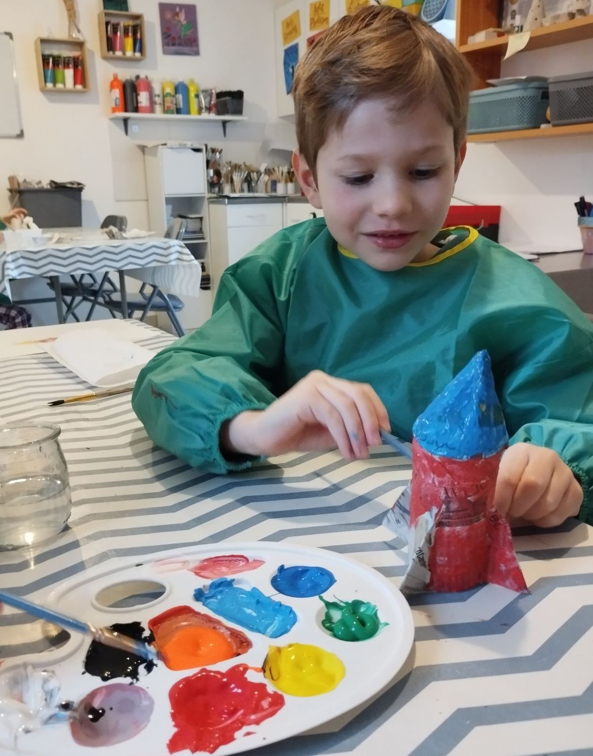 Un garçon peint à l'atelier