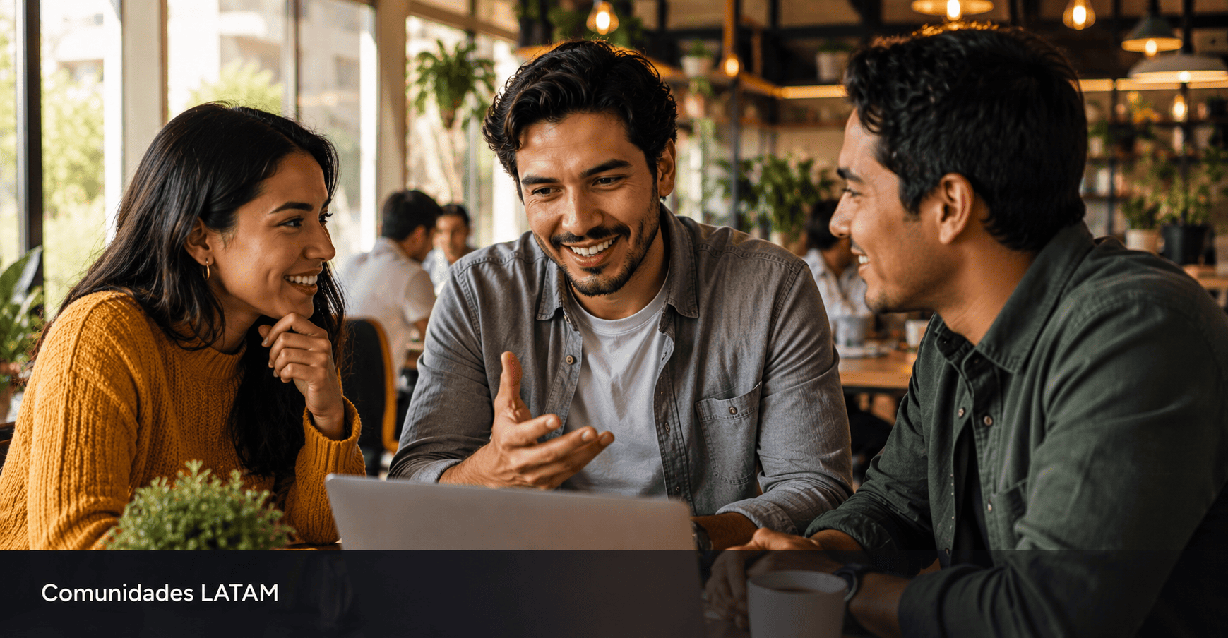 Grupo de jovenes latinoamericanos colaborando alrededor de laptop en coworking representando el poder de las comunidades.