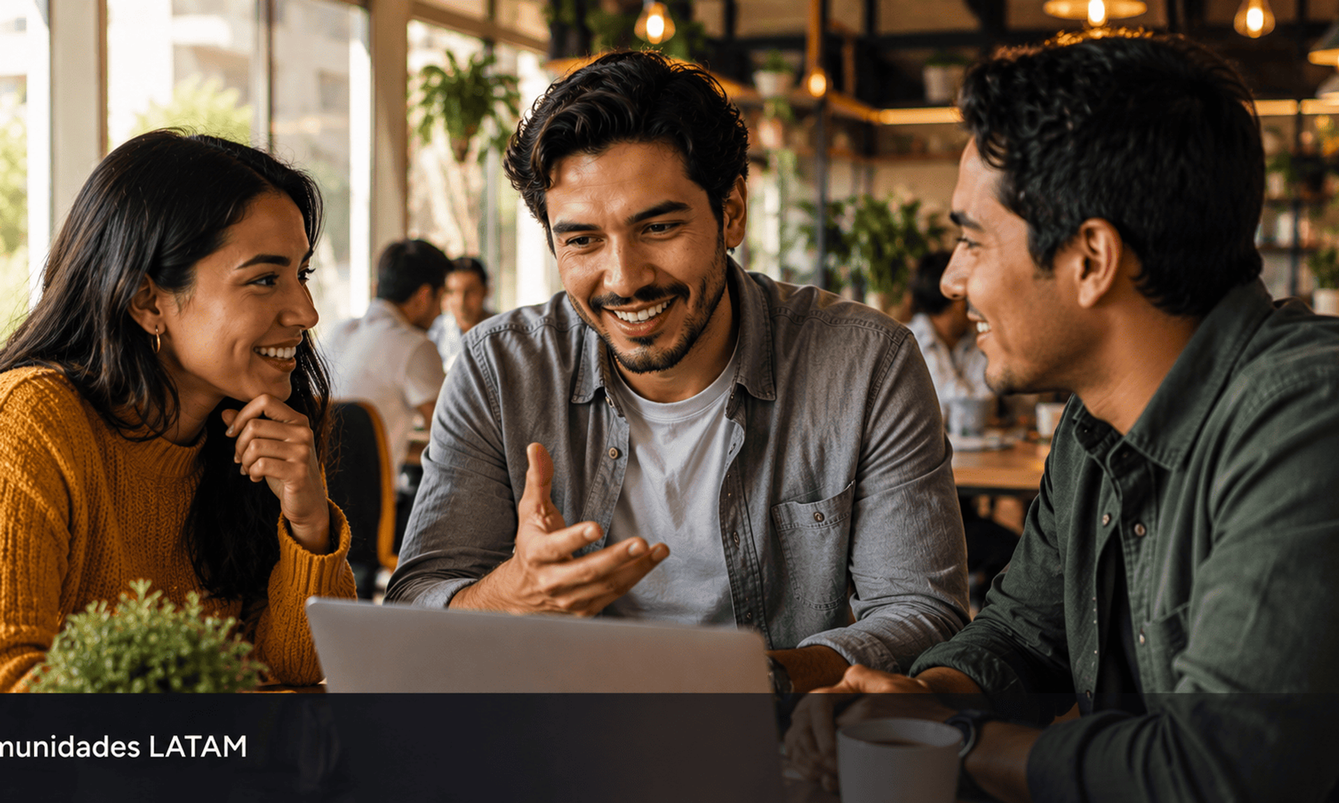 Grupo de jovenes latinoamericanos colaborando alrededor de laptop en coworking representando el poder de las comunidades.