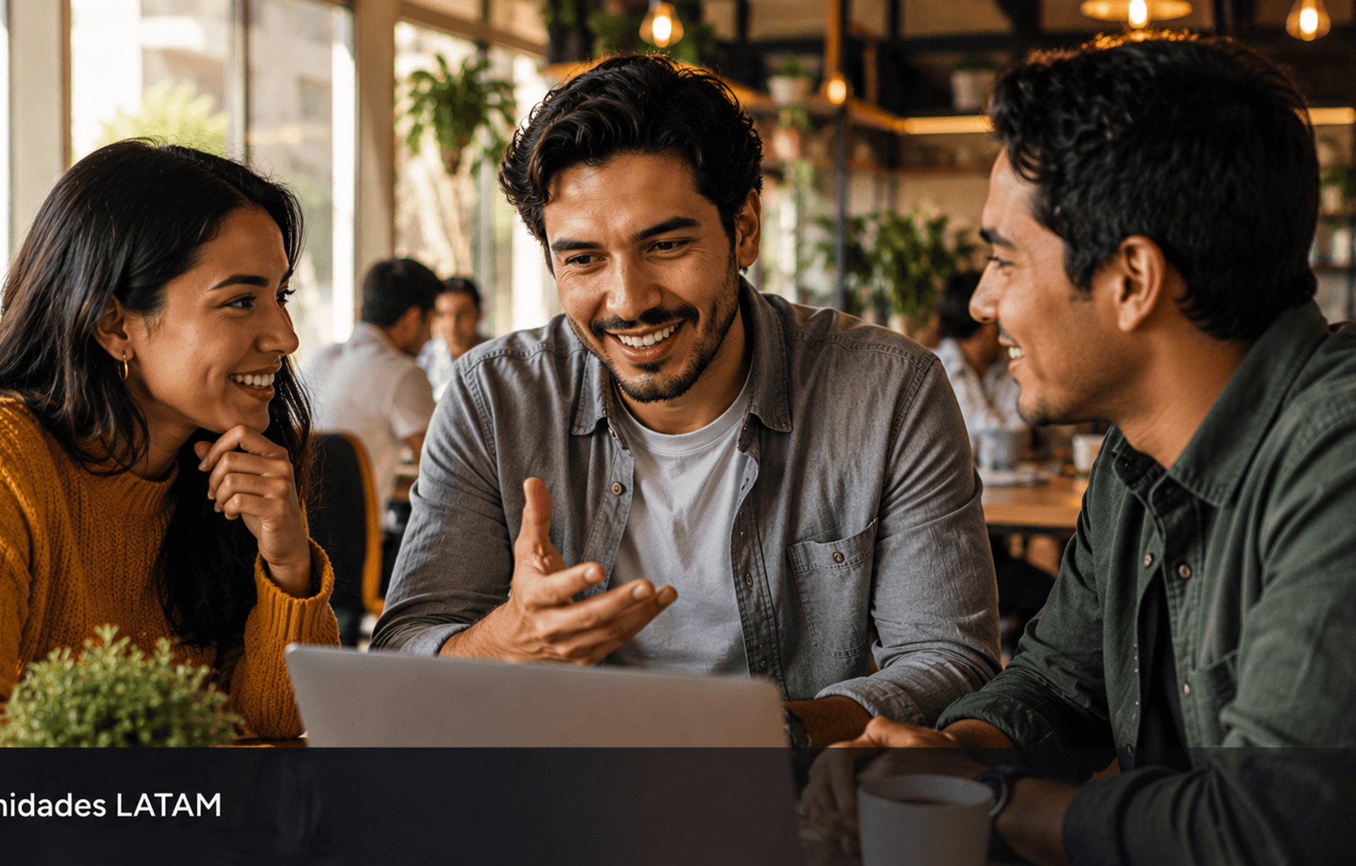 Grupo de jovenes latinoamericanos colaborando alrededor de laptop en coworking representando el poder de las comunidades.