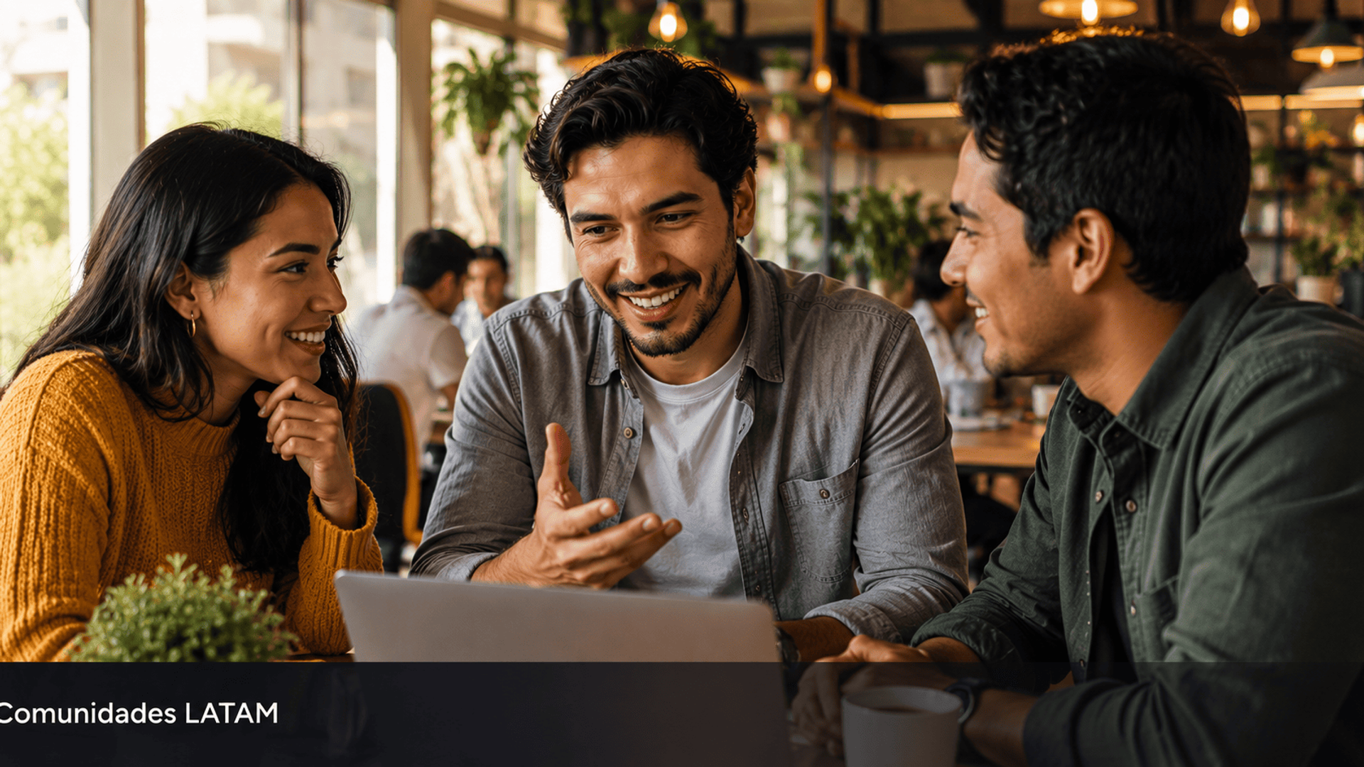 Grupo de jovenes latinoamericanos colaborando alrededor de laptop en coworking representando el poder de las comunidades.