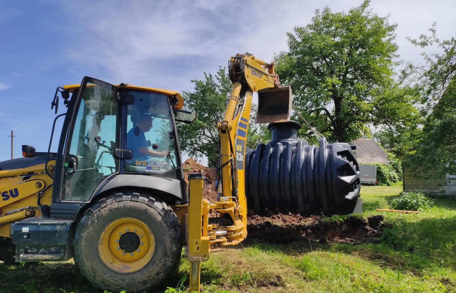Komatsu WB93R ekskavatorius leidžia biologinį nuotekų valymo įrenginį į iškastą duobę