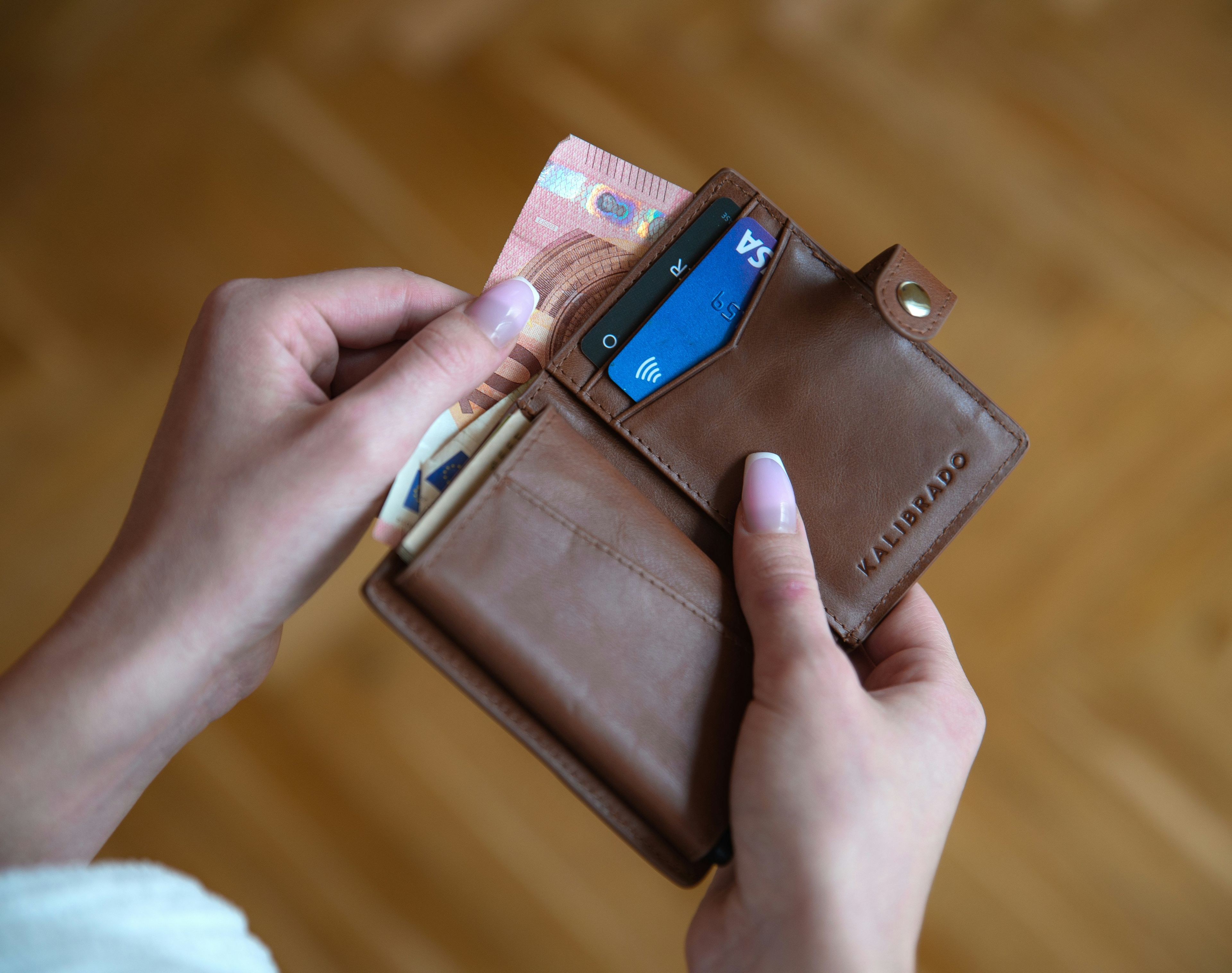 Person som håller plånbok.