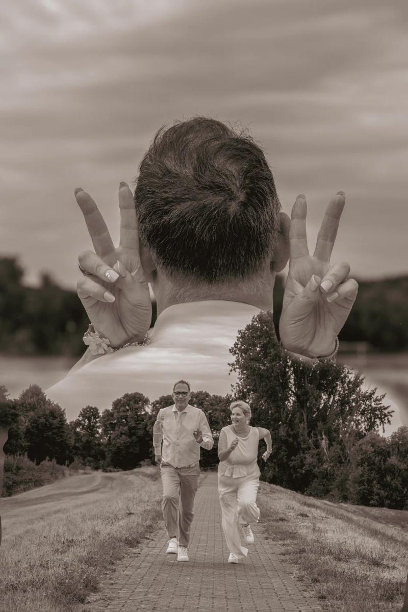 Doppelbelichtung: Ein Mann von hinten und ein lachendes Hochzeitspaar auf einem Weg.