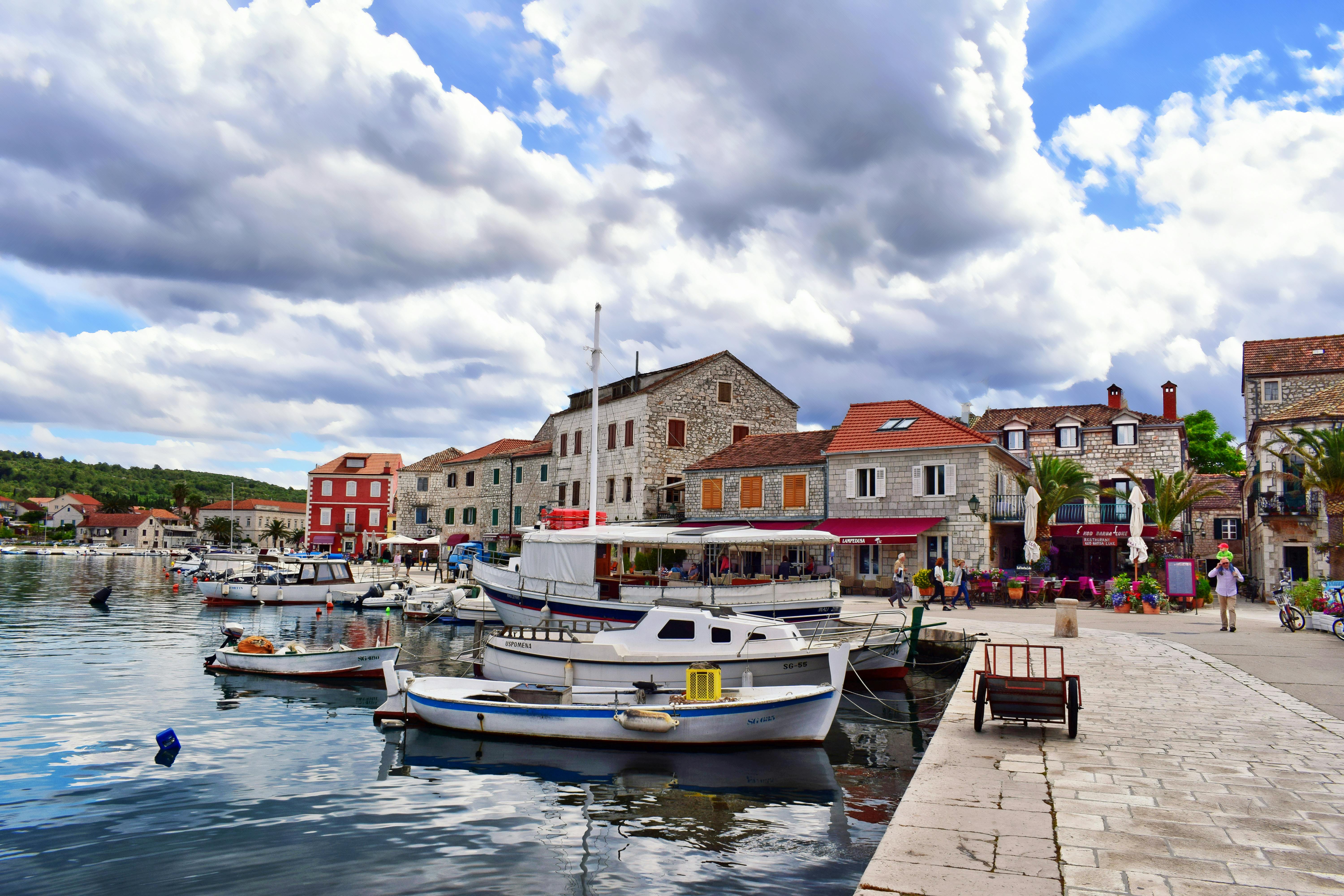 A sunny day at a harbour in Split, Croatia, with mountains and clear waters.