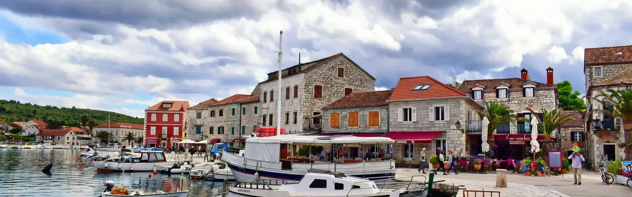 A sunny day at a harbour in Split, Croatia, with mountains and clear waters.