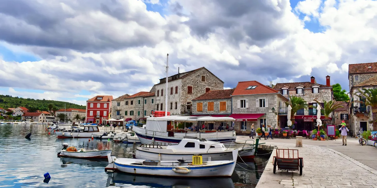 A sunny day at a harbour in Split, Croatia, with mountains and clear waters.