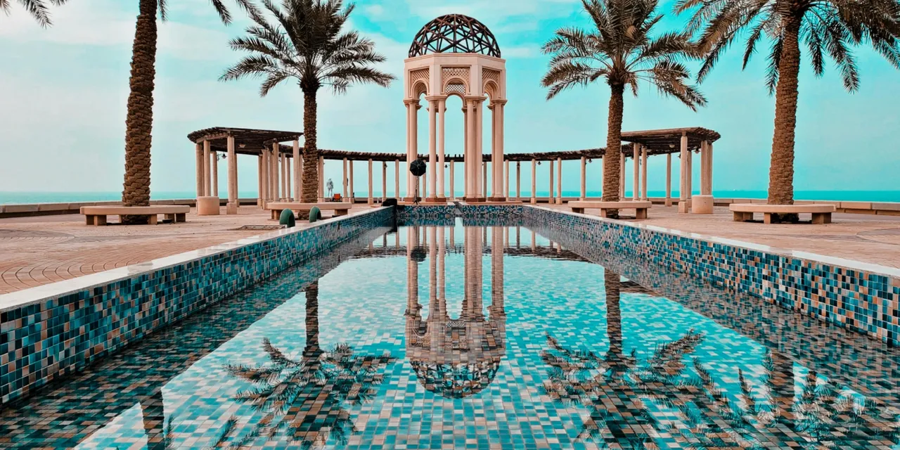 Moorish pavilion with tiled pool and palm trees overlooking the sea, Kuwait