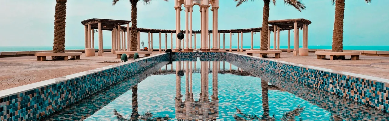 Moorish pavilion with tiled pool and palm trees overlooking the sea, Kuwait