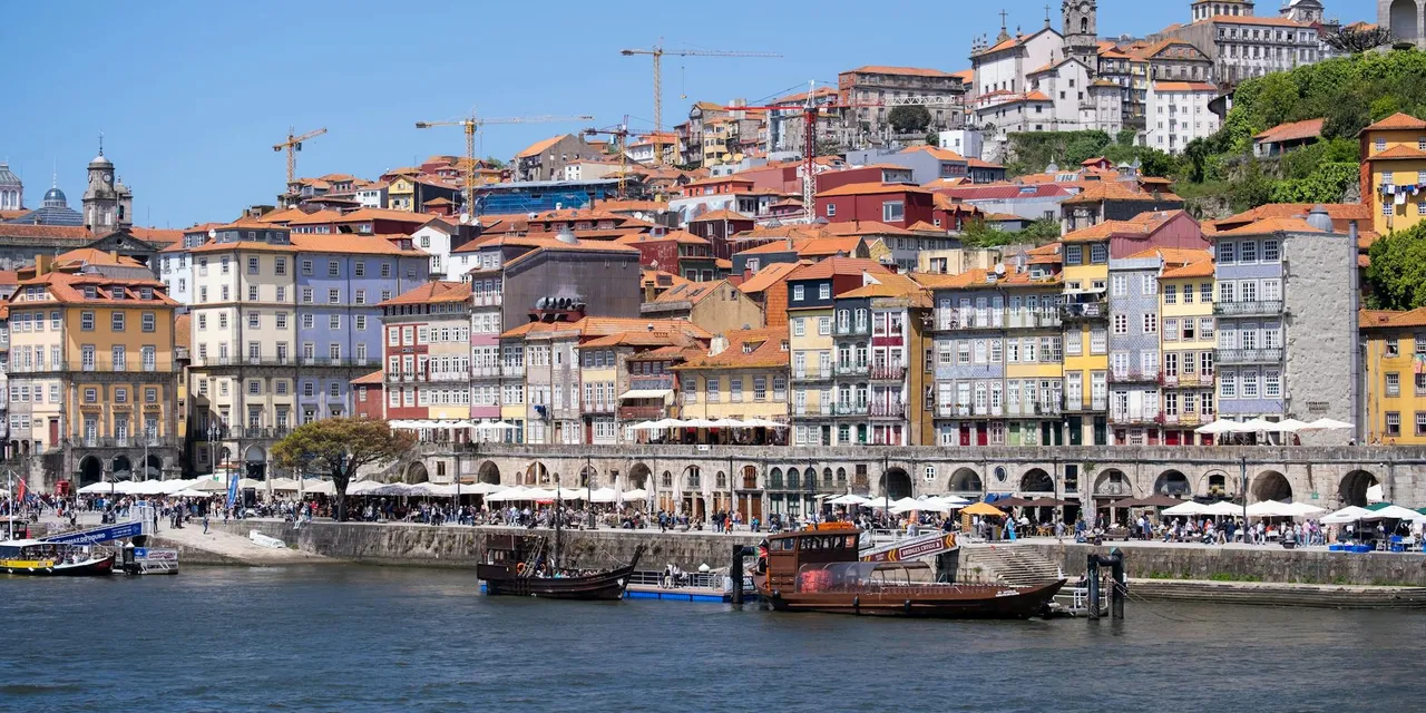 Colorful waterfront view of Ribeira District, Porto's historic charm under a bright sky.