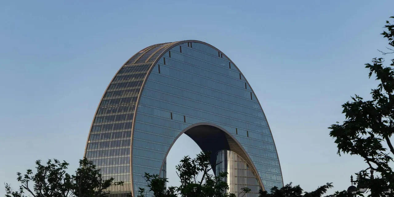 Architectural view of the modern Crescent Hotel in Baku, Azerbaijan against a clear sky.