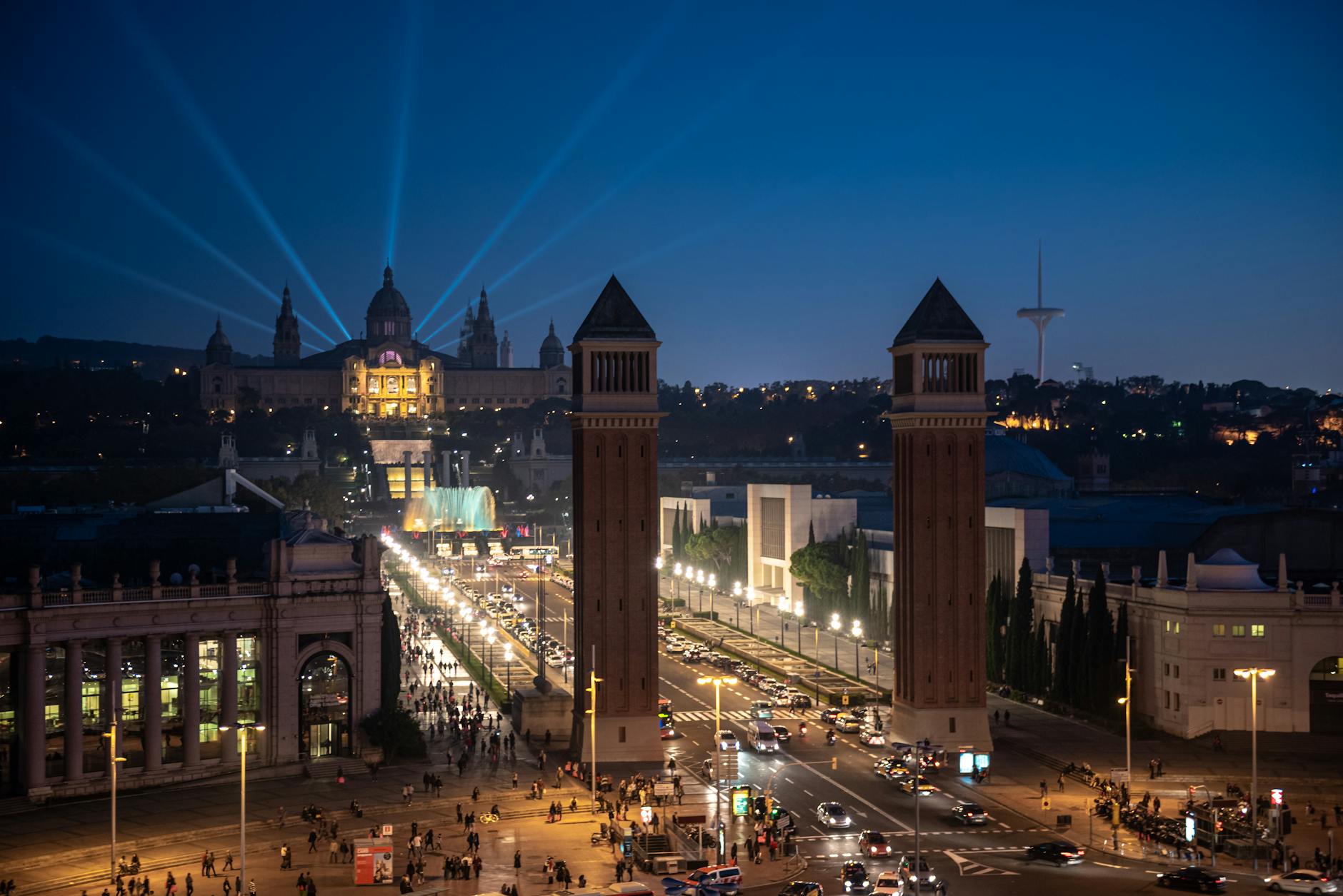 Night view of Barcelona's historic landmarks with vibrant lights and bustling streets.