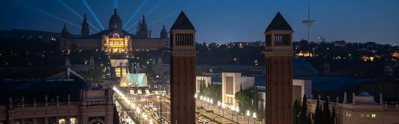Night view of Barcelona's historic landmarks with vibrant lights and bustling streets.