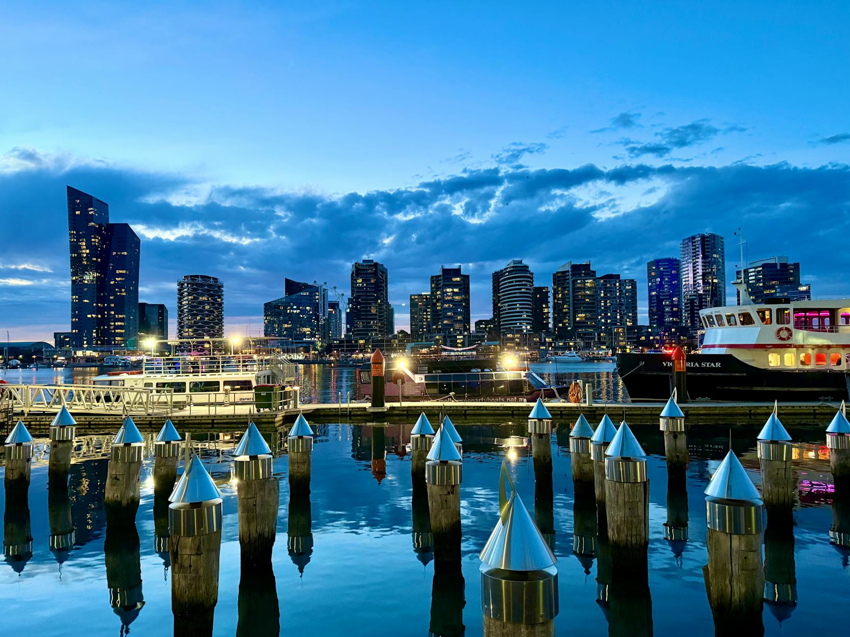 Twilight scene of Melbourne's striking skyline and harbor in Docklands, reflecting modern architecture.