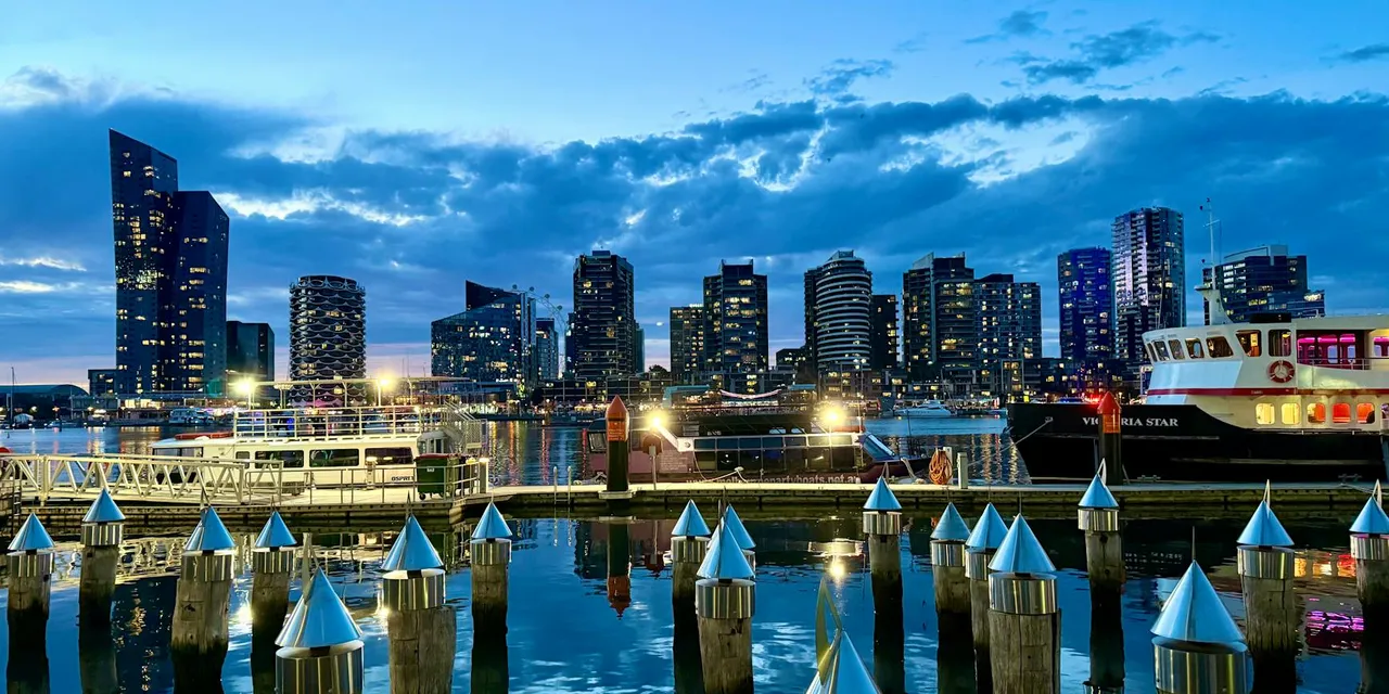 Twilight scene of Melbourne's striking skyline and harbor in Docklands, reflecting modern architecture.