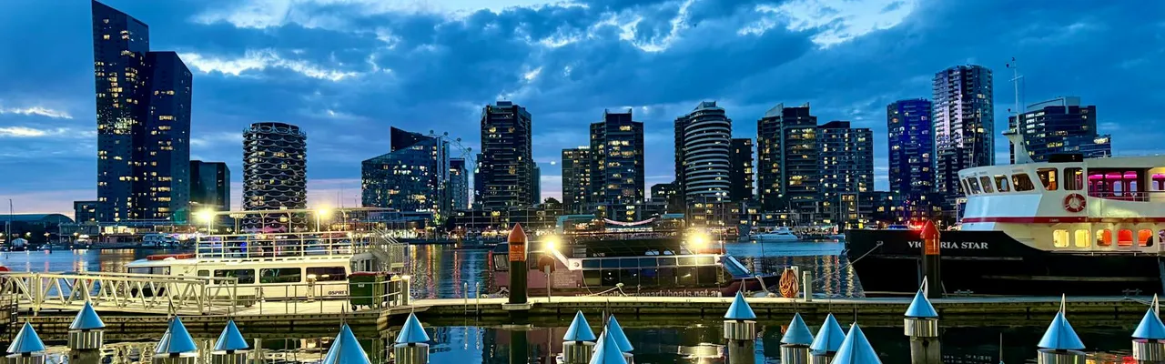 Twilight scene of Melbourne's striking skyline and harbor in Docklands, reflecting modern architecture.