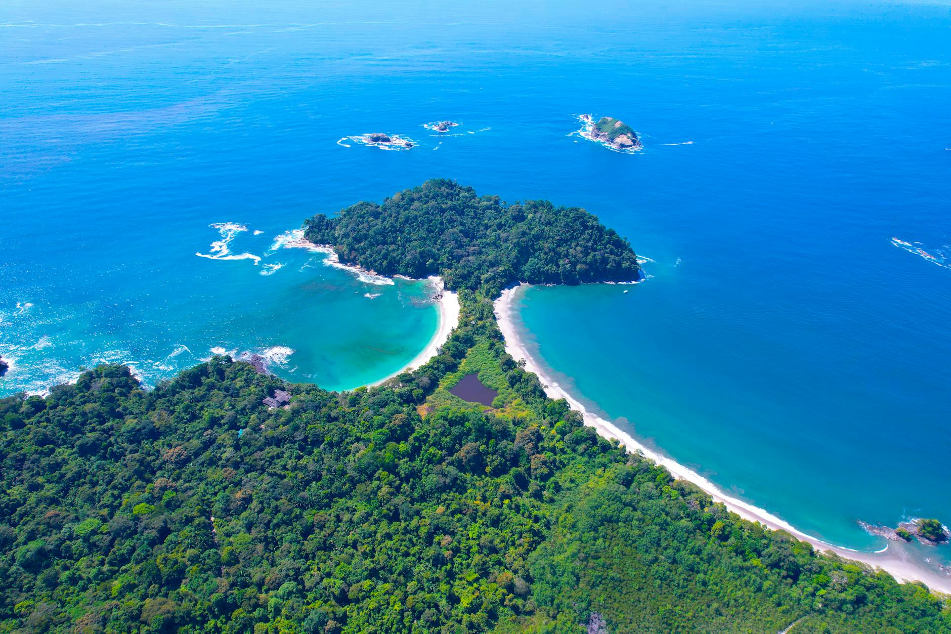 Stunning aerial shot of the lush coastline and turquoise waters of Manuel Antonio National Park, Costa Rica.