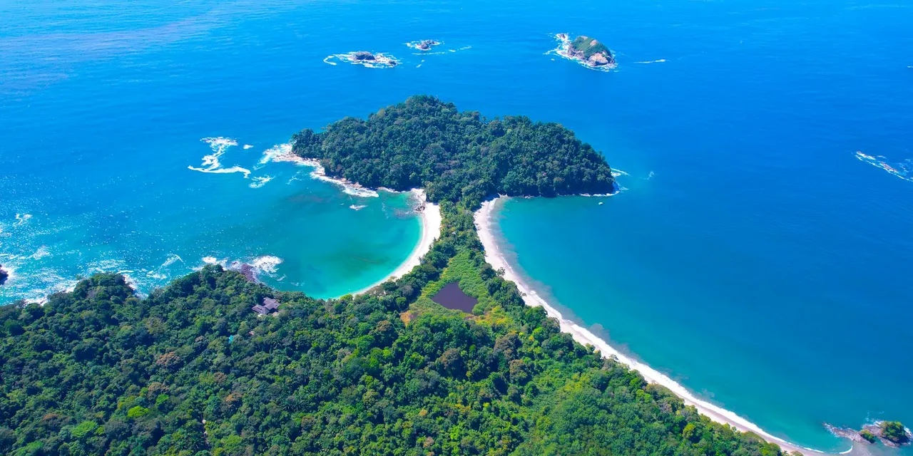 Stunning aerial shot of the lush coastline and turquoise waters of Manuel Antonio National Park, Costa Rica.