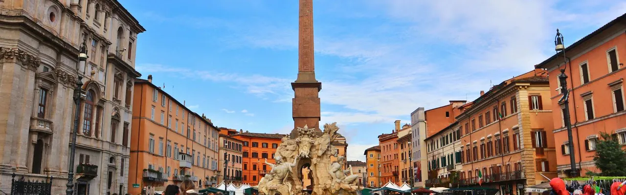 A bustling scene of Piazza Navona with the iconic Fountain of the Four Rivers in Rome, Italy.