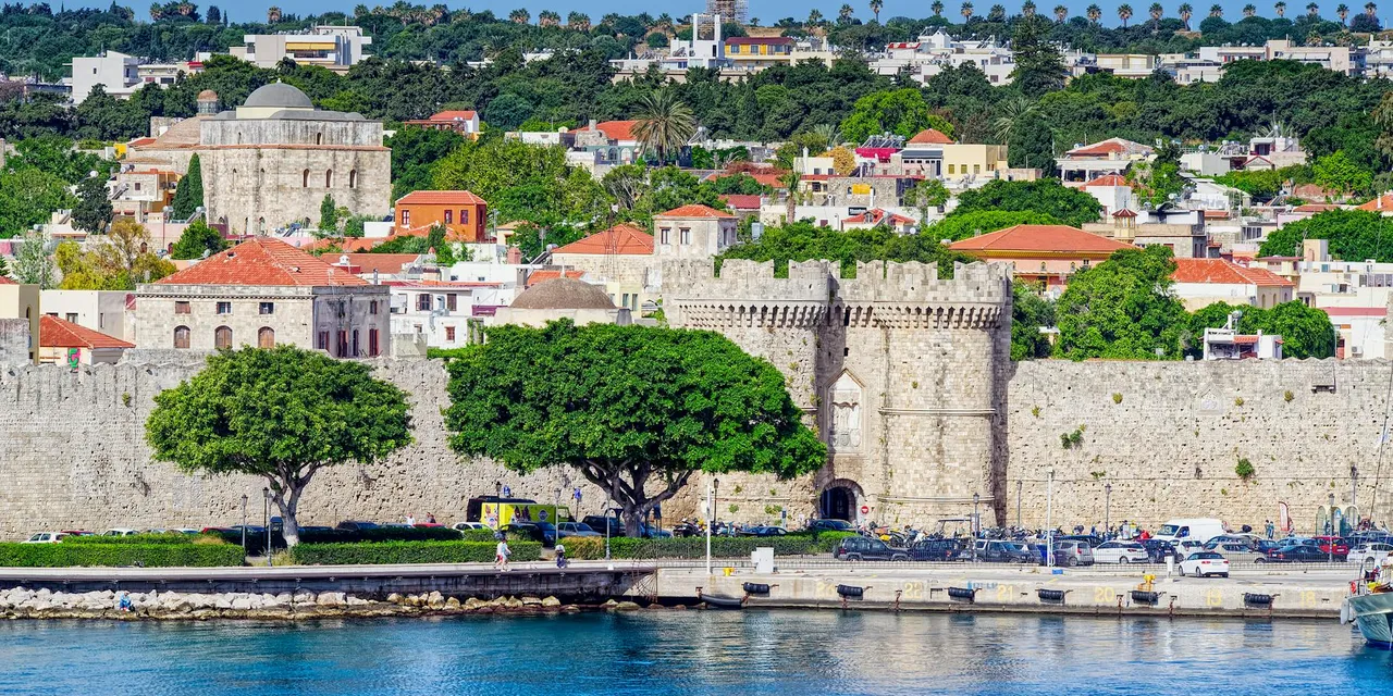 Beautiful view of the historic fortress in Rhodes, Greece, with vibrant cityscape and waterfront.
