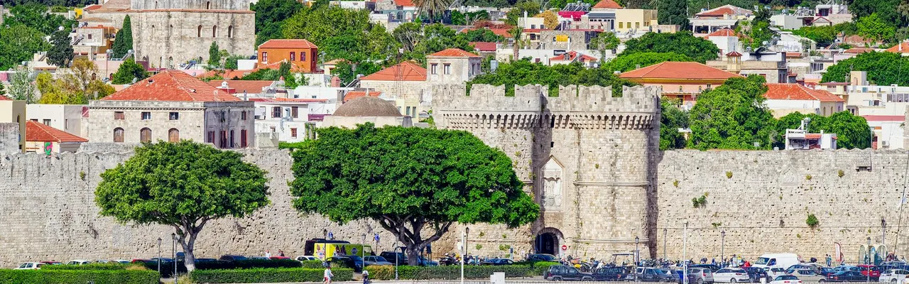 Beautiful view of the historic fortress in Rhodes, Greece, with vibrant cityscape and waterfront.