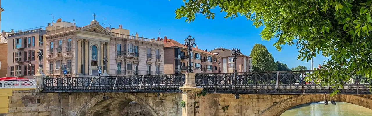 Scenic view of a historic Roman bridge in Murcia, Spain with clear blue sky.