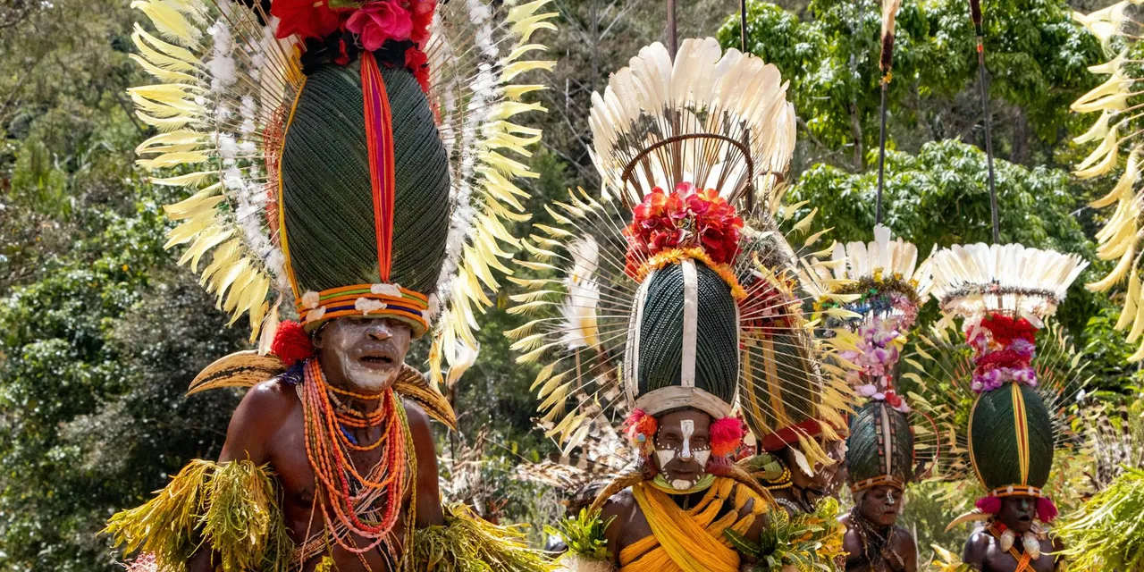 Colorful tribal dancers in traditional attire at a cultural festival in Papua New Guinea.
