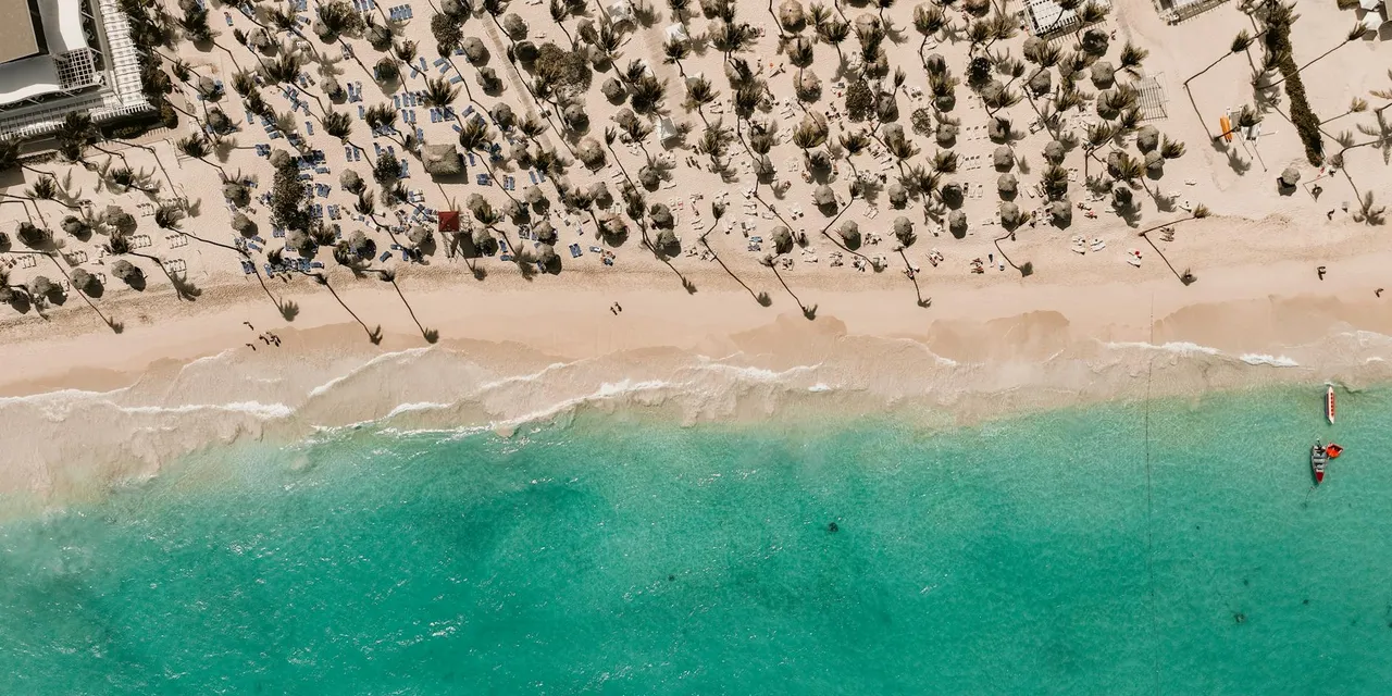 Stunning aerial view of a tropical beach in the Dominican Republic with white sand and turquoise water.