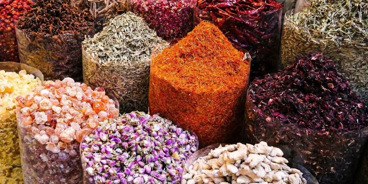 Colorful spices and dried flowers on display at Dubai's bustling spice souk market.