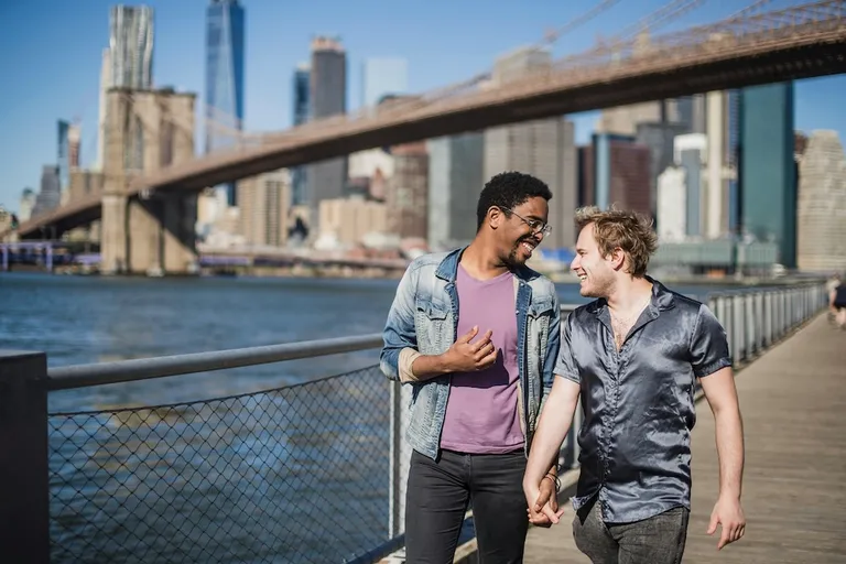 Gay couple travelling overseas by city river