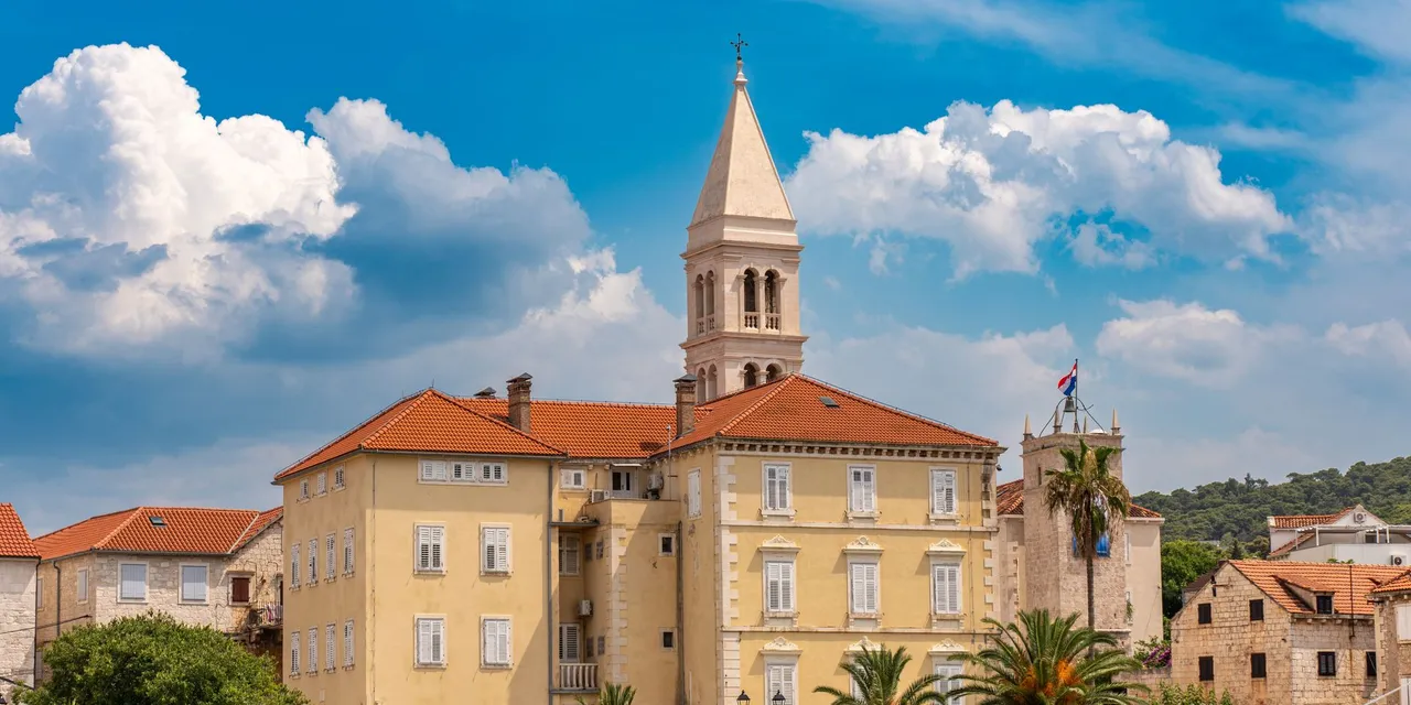Picturesque view of historic architecture in Supetar, Croatia, under a clear blue sky.