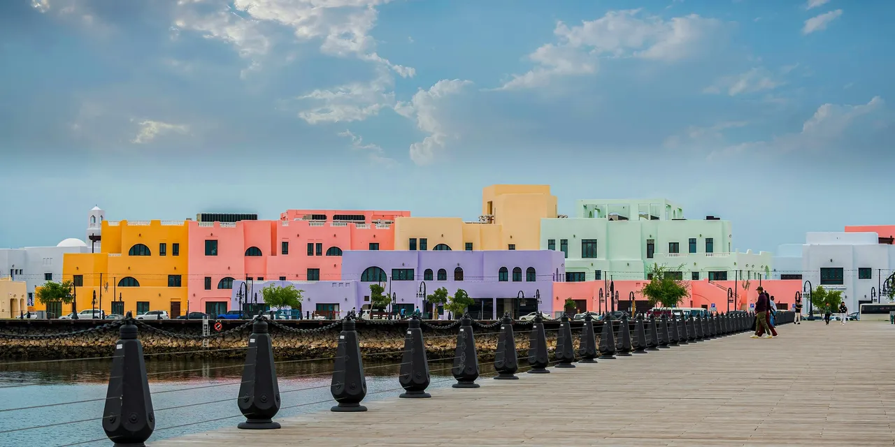 Pastel-coloured waterfront buildings along the Doha corniche promenade, Qatar