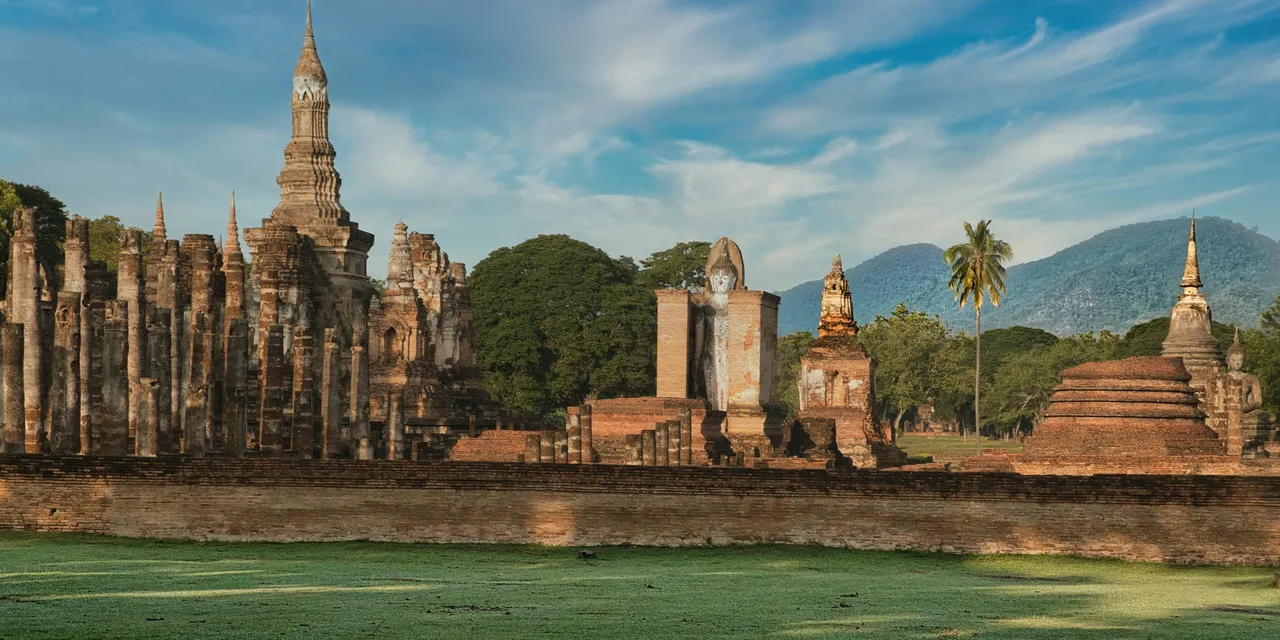 Ancient temple ruins of Sukhothai Historical Park with Buddha statues and stupas, Thailand