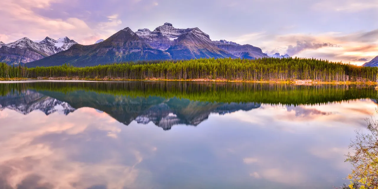 Beautiful reflection of mountains on Herbert Lake during sunset in Banff National Park, Canada.