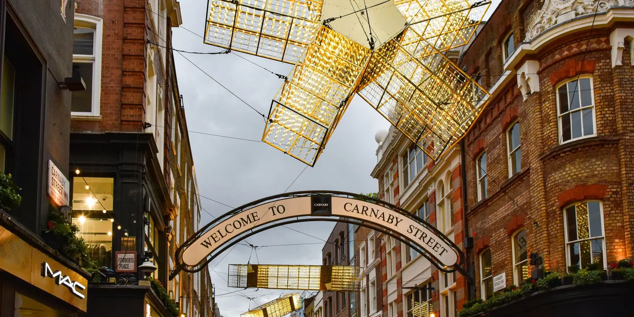 Bright festive lights on iconic Carnaby Street, London, showcasing vibrant city life.