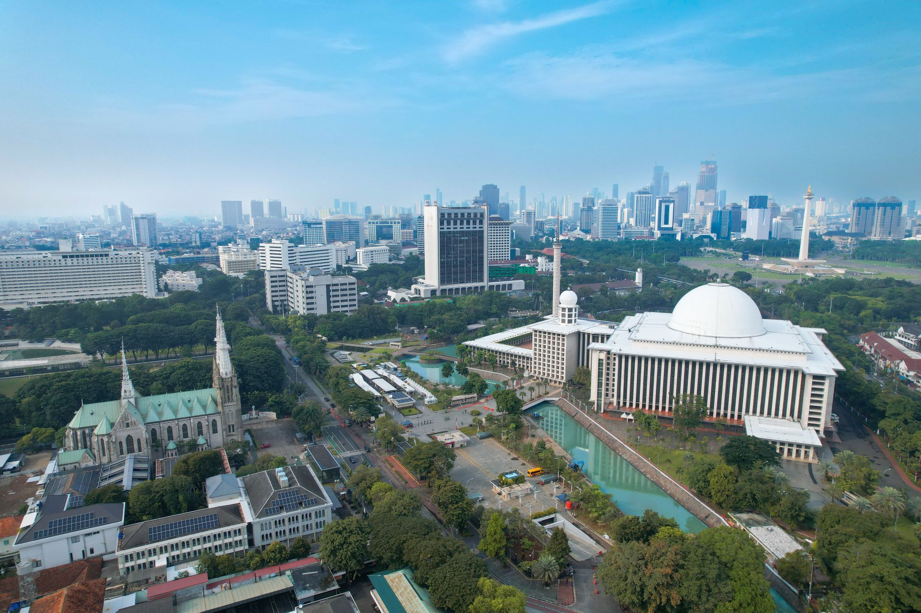 Stunning aerial shot of Istiqlal Mosque and Jakarta's modern skyline.