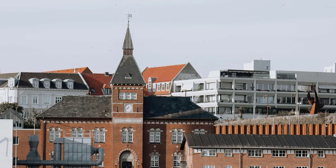 A striking historic brick building with a tower in Esbjerg, Denmark, under a clear sky.
