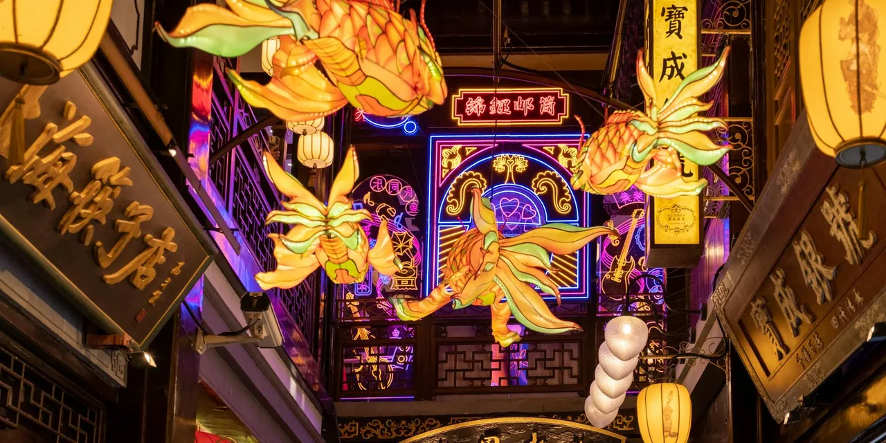 Colorful lantern display illuminating a bustling urban alley at night.