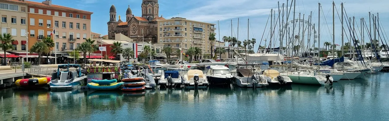 Scenic view of Saint-Tropez marina with boats and the iconic cathedral on a sunny day.