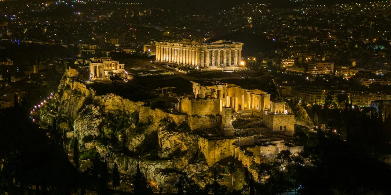 A stunning night aerial view of the illuminated Acropolis in Athens, Greece.
