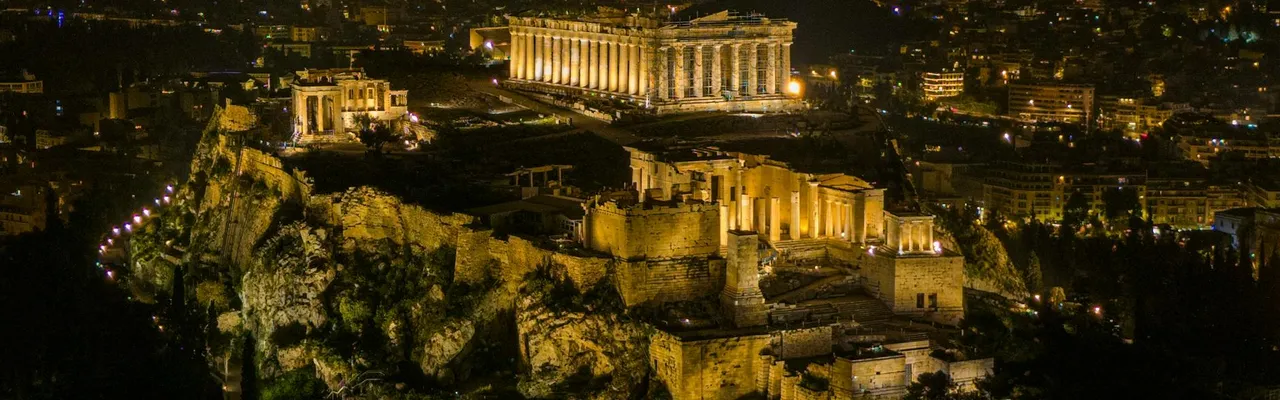 A stunning night aerial view of the illuminated Acropolis in Athens, Greece.